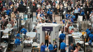 Travelers queue up at the south security checkpoint in Denver International Airport as the Labor Day holiday approaches, Aug. 30, 2022, in Denver.