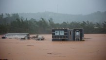 Three people inside a house await rescue from the floods caused by Hurricane Fiona in Cayey, Puerto Rico, Sunday, September 18, 2022. (AP Photo/Stephanie Rojas)