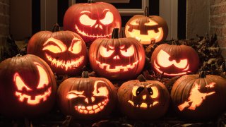 Night shot of illuminated pumpkins in front of a house.
