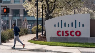 A runner jogs past Cisco Systems headquarters in San Jose, California, U.S., on Monday, Feb. 8, 2021.