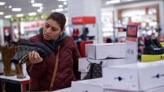 A customer searches for shoe products inside a Macy’s store during Black Friday sales on November 25, 2022 in Jersey City, New Jersey.