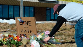 Elijah Newcomb of Colorado Springs lays flowers