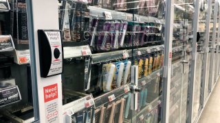 Anti-theft locked beauty products with customer service button at Walgreens pharmacy, Queens, New York.