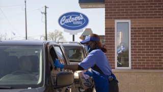 Culver&apos;s employee Teesha Nelson hands a drive-thru customer their order on Nov. 8, 2021, outside the restaurant chain&apos;s newest location in Pullman on its opening day. (Raquel Zaldivar/Chicago Tribune/Tribune News Service via Getty Images)