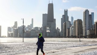 A man runs by North Ave. Beach in Chicago, the United States, on Dec. 24, 2022. A strong winter storm swept through Chicago. (Photo by Joel Lerner/Xinhua via Getty Images)