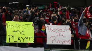 Portland Thorns fans hold signs during the first half of the team’s National Women’s Soccer League soccer match against the Houston Dash in Portland, Ore., Oct. 6, 2021.