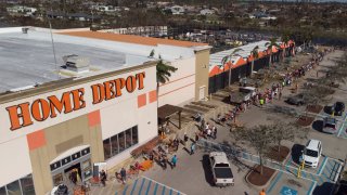 People queue up outside a Home Depot as they wait to shop for power generators and other supplies after Hurricane Ian caused widespread destruction in Cape Coral, Florida, September 30, 2022.
