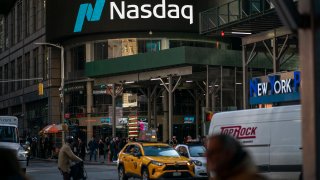 People walk near the Nasdaq building in Times Square on January 24, 2023. in New York City.
