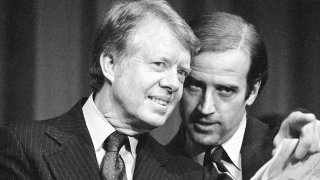 FILE – In this Feb. 20, 1978, file photo, President Jimmy Carter listens to Sen. Joseph R. Biden, D-Del., as they wait to speak at fund raising reception at Padua Academy in Wilmington, Del.