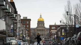 A pedestrian crosses the street near the Iowa State Capitol in Des Moines, Iowa, U.S., on Monday, Feb. 3, 2020.