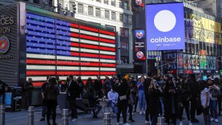 Employees of Coinbase Global Inc, the biggest U.S. cryptocurrency exchange, watch as their listing is displayed on the Nasdaq MarketSite jumbotron at Times Square in New York, April 14, 2021.