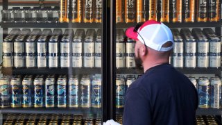 A baseball fan looks at the offerings in a beer cooler at PNC Park before a baseball game between the Pittsburgh Pirates and the Houston Astros in Pittsburgh, Wednesday, April 12, 2023.