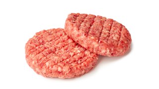 Two raw burger patties isolated on white background. Clipping path included