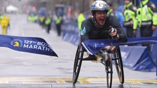 Marcel Hug of Switzerland crosses the finish line and takes first place in the professional Men's Wheelchair Division during the 127th Boston Marathon on April 17, 2023 in Boston, Massachusetts.