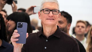 Apple CEO Tim Cook holds the new iPhone 14 at an Apple event at their headquarters in Cupertino, California, September 7, 2022.