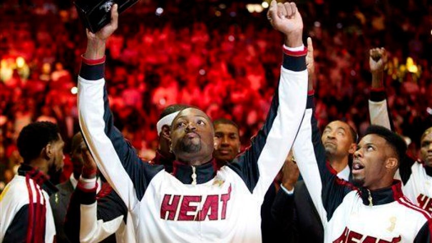 Miami Heat’s Dwyane Wade holds his 2012 NBA Finals championship ring during a ceremony before a basketball game against the Boston Celtics, Tuesday, Oct. 30, 2012, in Miami. (AP Photo/J Pat Carter)