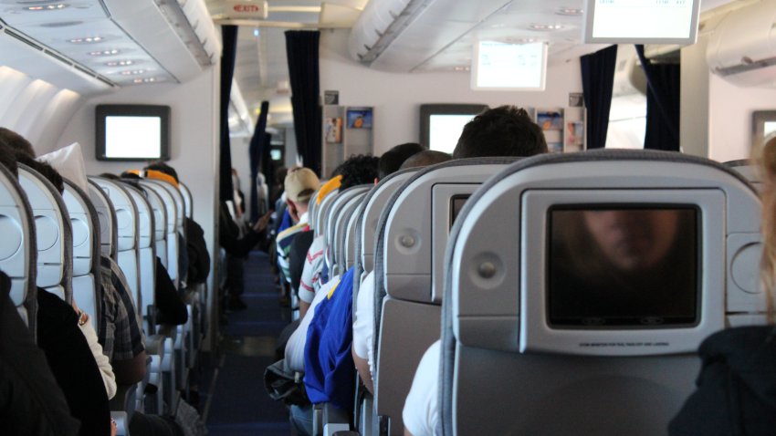 Passengers in aircraft wait for takeoff.