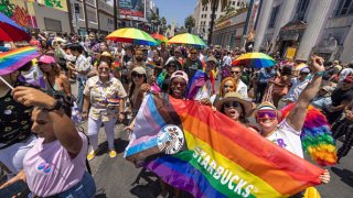 Marchers with Starbucks pass through the landmark intersection of Hollywood and Highland during the annual Pride Parade in Los Angeles, June 12, 2022.