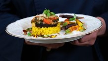 A chef holds the main course, stuffed portobello mushrooms with a creamy saffron-infused risotto, that will be served at Thursday evening's State Dinner with India, during a media preview, Wednesday, June 21, 2023, at the White House in Washington. 