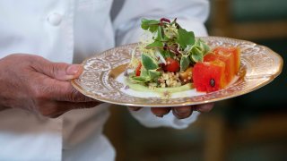 A chef holds the first course, a marinated millet and grilled corn kernel salad with compressed watermelon and a tangy avocado sauce, that will be served at Thursday evening’s State Dinner with India, during a media preview, Wednesday, June 21, 2023, at the White House in Washington. (AP Photo/Jacquelyn Martin)