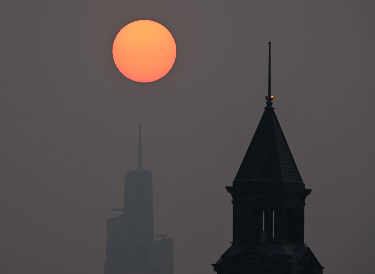 The sun is shrouded as it rises in a hazy, smoky sky due to the Canadian wildfires in New York City of United States on June 7, 2023.