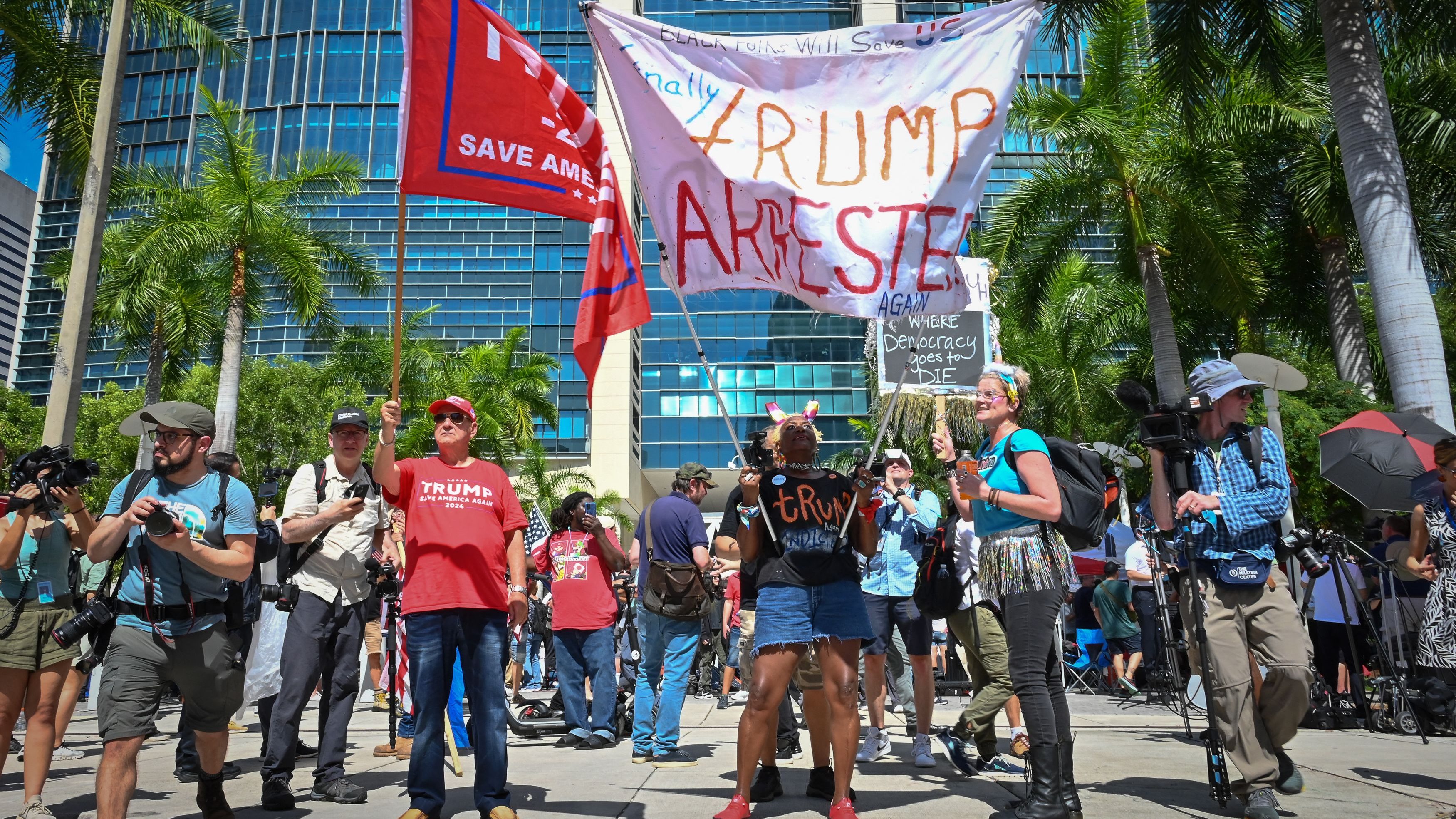 Trump supporters and protesters hold signs in front of the Wilkie D. Ferguson Jr. United States Courthouse before the arraignment of former President Donald Trump in Miami, June 13, 2023. Trump is appearing in court for an arraignment regarding 37 federal charges, including violations of the Espionage Act.