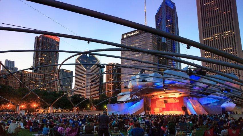 Millennium Park, crowd at Grant Park Symphony the Jay Pritzker Pavilion, a band shell designed by Frank Gehry, skyscrapers of the downtown on the background, Chicago, Illinois, USA. (Photo by: Education Images/Universal Images Group via Getty Images)