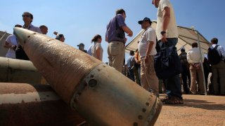 FILE – Activists and international delegations stand next to cluster bomb units, during a visit to a Lebanese military base at the opening of the Second Meeting of States Parties to the Convention on Cluster Munitions, in the southern town of Nabatiyeh, Lebanon, Sept. 12, 2011.