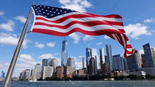 An American flag flies off the back of the retired FDNY John J. Harvey fireboat as it sails past lower Manhattan and One World Trade Center while taking part in a 9/11 commemorative flotilla in the Hudson River on September 10, 2021 in New York City.