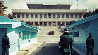 FILE – Rear view of soldiers standing at demilitarized zone between North and South Korea.