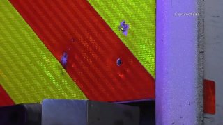 Bullet holes are visible in the red-and-yellow-striped door of a Chicago Fire Department ambulance.