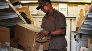 A UPS worker checks an Amazon box to be delivered in New York.