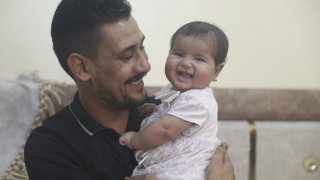Khalil al-Sawadi plays with his adopted daughter Afraa in Jinderis, Syria,