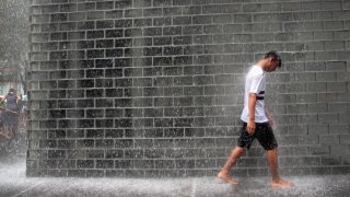 CHICAGO, ILLINOIS  – JULY 19: A visitor cools off in Crown Fountain in downtown as temperatures are forecast to head into the mid to high 90’s with a heat index of around 115 degrees on July 19, 2019 in Chicago, Illinois. The heat wave gripping the city is affecting nearly two-thirds of the United states where more than 195 million people will experience temperatures above 90 degrees over the next few days.  (Photo by Scott Olson/Getty Images)