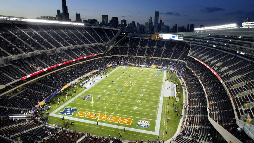 This photo shows a view of the newly renovated Soldier Field, the home of the NFL’s Chicago Bears, with the Chicago skyline in the background 29 September, 2003 on opening night of the new stadium as the Chicagp Bears prepare to take on the Green Bay Packers. The stadium was renovated  with a cost of 632 million USD, with a seating capacity of 61,500. The new stadium bowl sits inside the historic facade of the original Soldier Field, which was built in 1924 as a memorial to US soldiers.    AFP PHOTO/Jeff HAYNES  (Photo credit should read JEFF HAYNES/AFP via Getty Images)