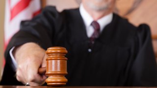 A close-up of a judge’s gavel in his hand in the courtroom.