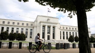A cyclist passes the Federal Reserve building in Washington, DC, August 22, 2018.