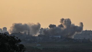 Smoke rises from buildings, viewed from the Israeli side of the border, as the Israeli military conducts a bombardment on Oct. 15, 2023 in northern Gaza. UNRWA, the UN Palestinian refugee agency, said its staff in Gaza can no longer to provide humanitarian assistance.