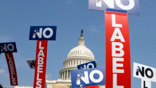 People with the group No Labels hold signs during a rally on Capitol Hill in Washington, July 18, 2011. More than 15,000 people in Arizona have registered to join a new political party floating a possible bipartisan “unity ticket” against Joe Biden and Donald Trump.