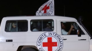 A Red Cross vehicle, as part of a convoy believed to be carrying hostages abducted by Hamas militants during the October 7 attack on Israel, arrives at the Rafah border, amid a hostages-prisoners swap deal between Hamas and Israel, as seen from southern Gaza Strip November 24, 2023. 