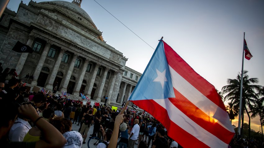 A demonstrator waves a Puerto Rican flag outside the Capitol building during a protest against the government in San Juan, Puerto Rico, on Monday, Jan. 20, 2020.