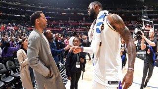 FILE - Businessman Maverick Carter talks with LeBron James