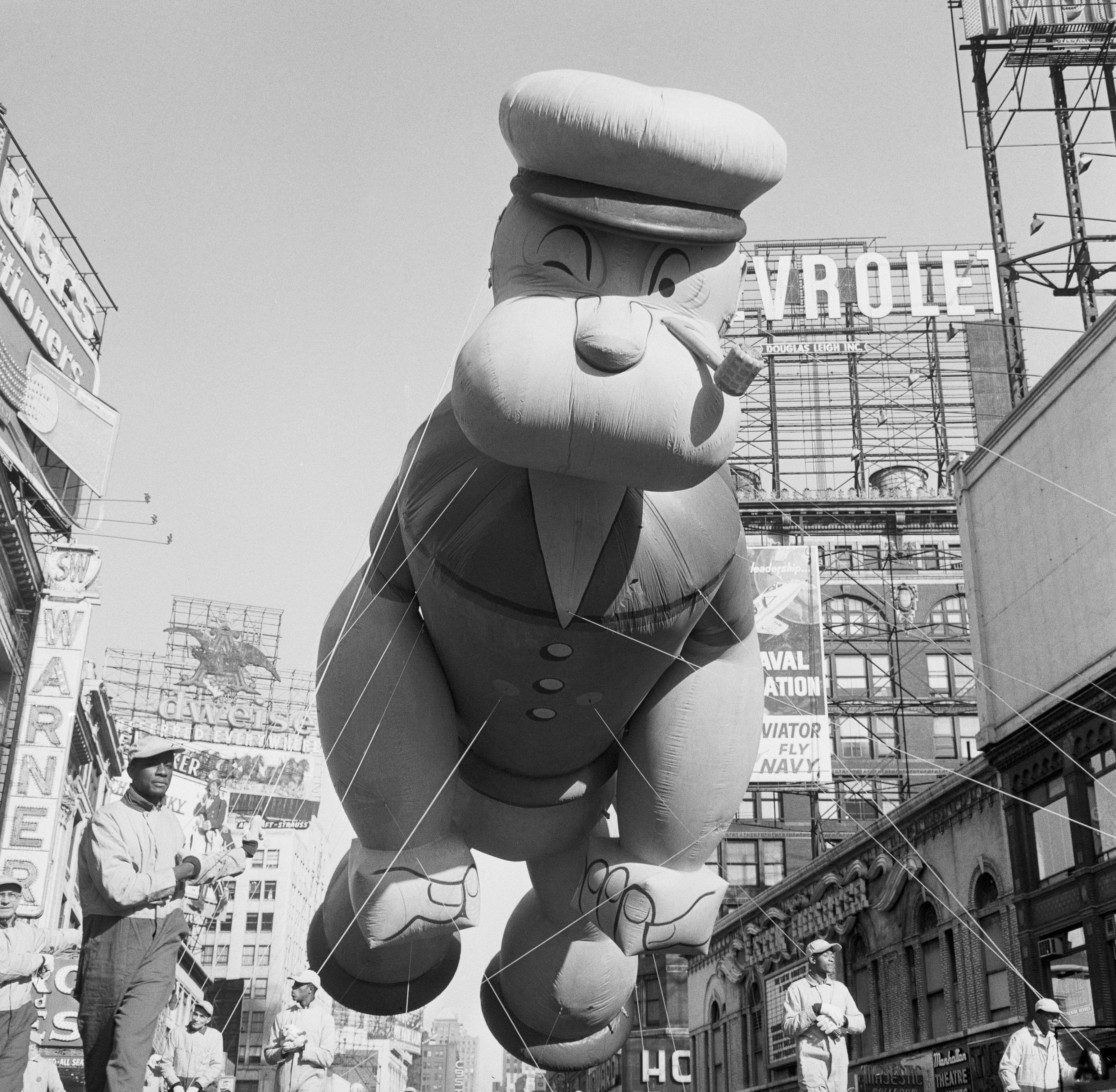 (Original Caption) New York: Thanksgiving Day – Macy’s Parade. ‘Here comes Popeye. The pipe-puffing sailor man, high-strung and swaying in a brisk breeze, floats over Times Square as one of the balloon characters in Macy’s Thanksgiving Day parade. A million kids of all ages saw it.’