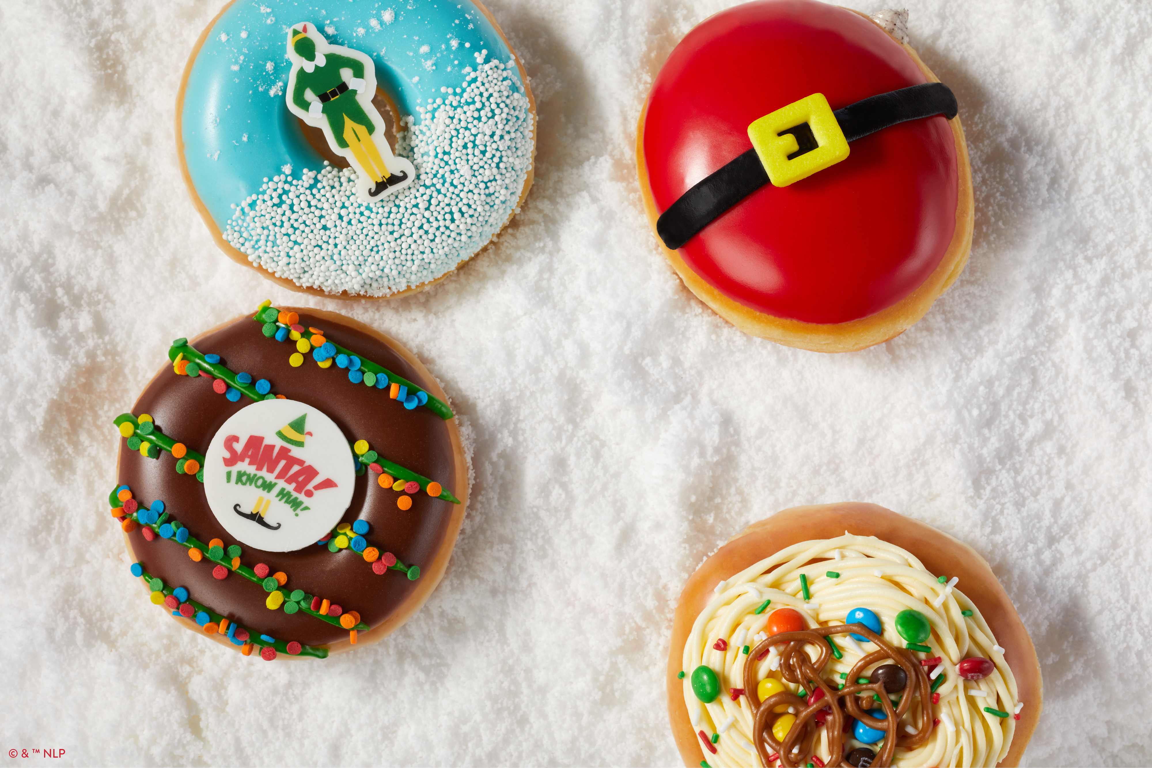 Four Elf-themed Krispy Kreme donuts on a bed of snow.