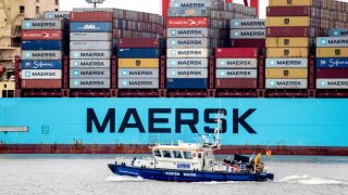 A boat of the Lower Saxony water police sails along in front of the container ship “Morten Maersk” of the Danish shipping company Maersk Line, which is moored at a quay wall at the container terminal JadeWeserPort.