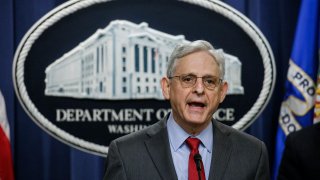 Merrick Garland in front of Department of Justice sign