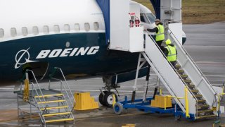 FILE - Workers are pictured next to a Boeing 737 MAX 9 airplane on the tarmac at the Boeing Renton Factory in Renton, Washington, on March 12, 2019.