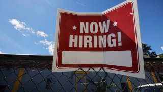 A “now hiring” sign is displayed outside Taylor Party and Equipment Rentals in Somerville, Massachusetts, September 1, 2022.
