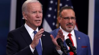 U.S. President Joe Biden speaks on the student debt relief plan as Secretary of Education Miguel Cardona (R) listens in the South Court Auditorium at the Eisenhower Executive Office Building on October 17, 2022 in Washington, DC.