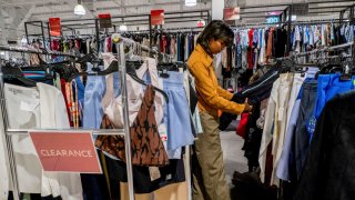 A person picks out clothing in a store as retailers compete to attract shoppers and try to maintain margins on Black Friday, one of the busiest shopping days of the year, at Woodbury Common Premium Outlets in Central Valley, New York, U.S. November 24, 2023.